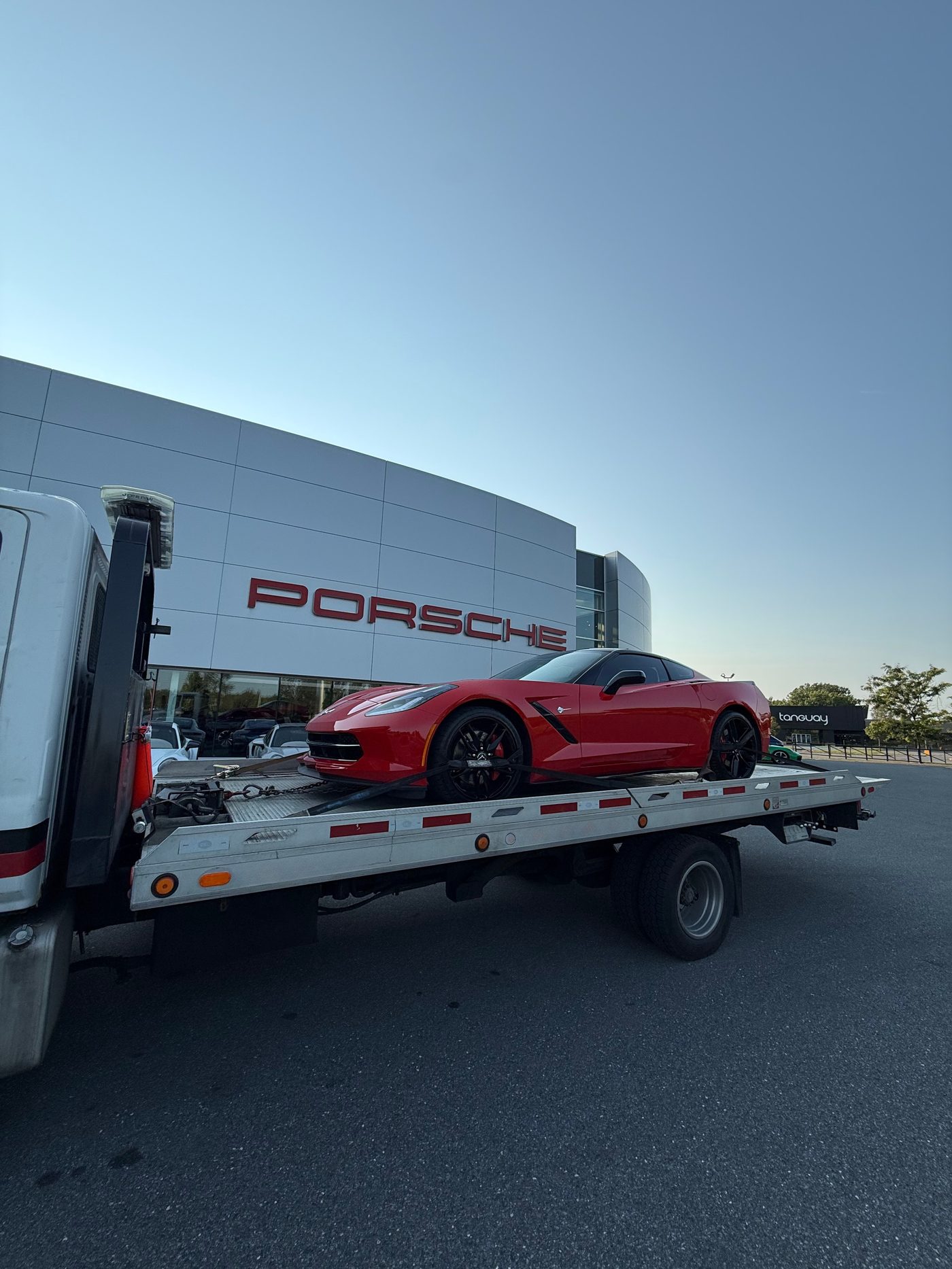 Sports car loaded on the A2B flatbed at a dealership